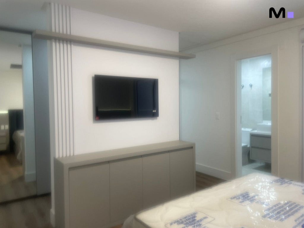 Quarto moderno com TV e armário no Condomínio House Haras. Design clean e elegante.