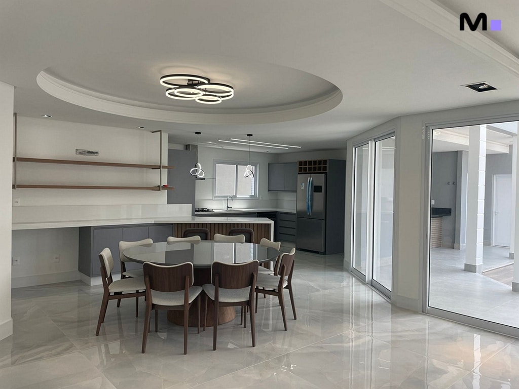 Cozinha moderna e espaçosa no Condomínio House Haras, com mesa de jantar e iluminação elegante.