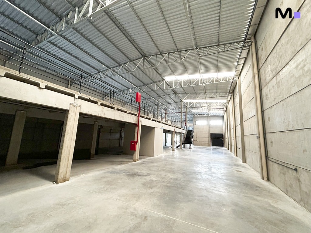 Interior espaçoso do ABC Business Park, com mezanino e piso de concreto.