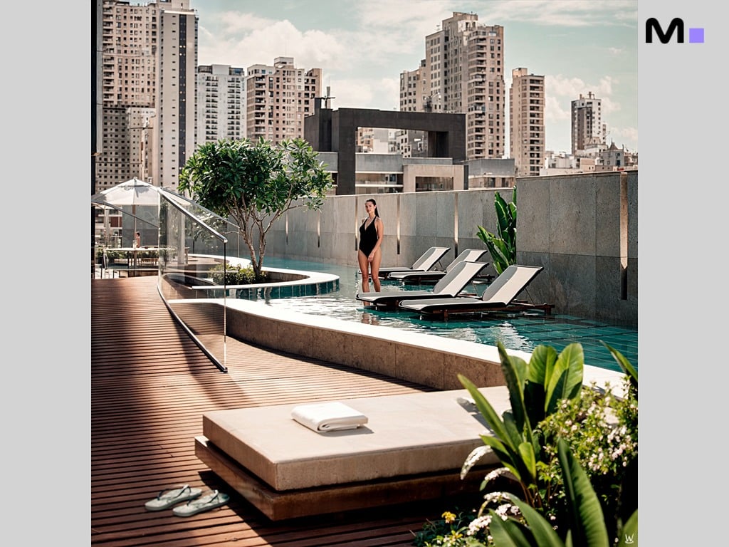 Mulher de maiô na piscina do Nilo Residence com vista para a cidade.
