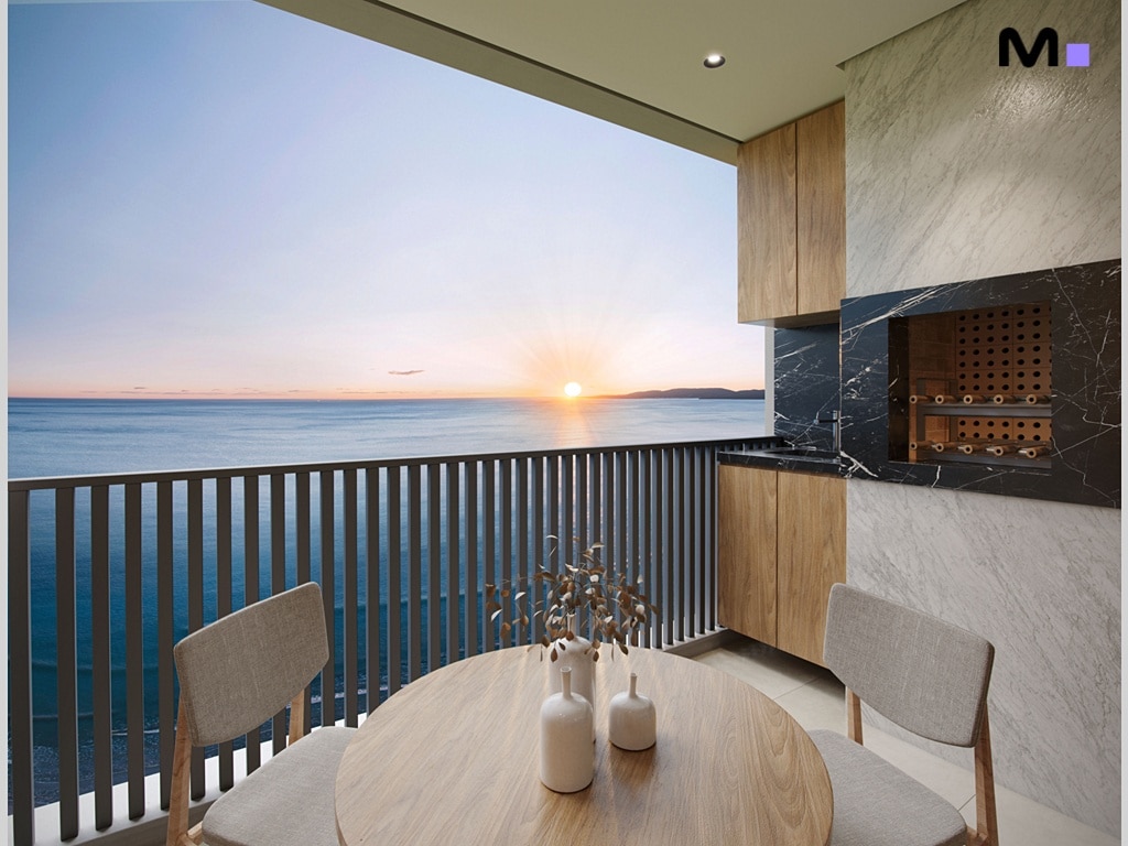 Varanda com churrasqueira, mesa e vista para o mar ao pôr do sol, ideal para uma soirée relaxante.