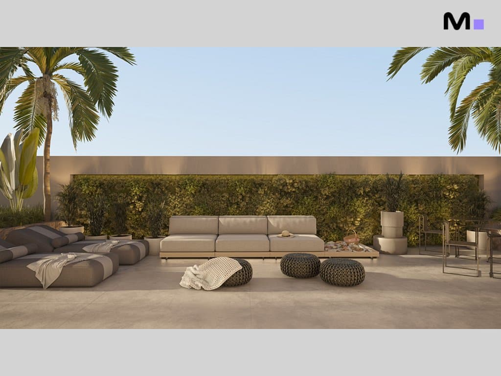 Área externa da Torre Del Mare Residence com sofás, pufes e vegetação exuberante.