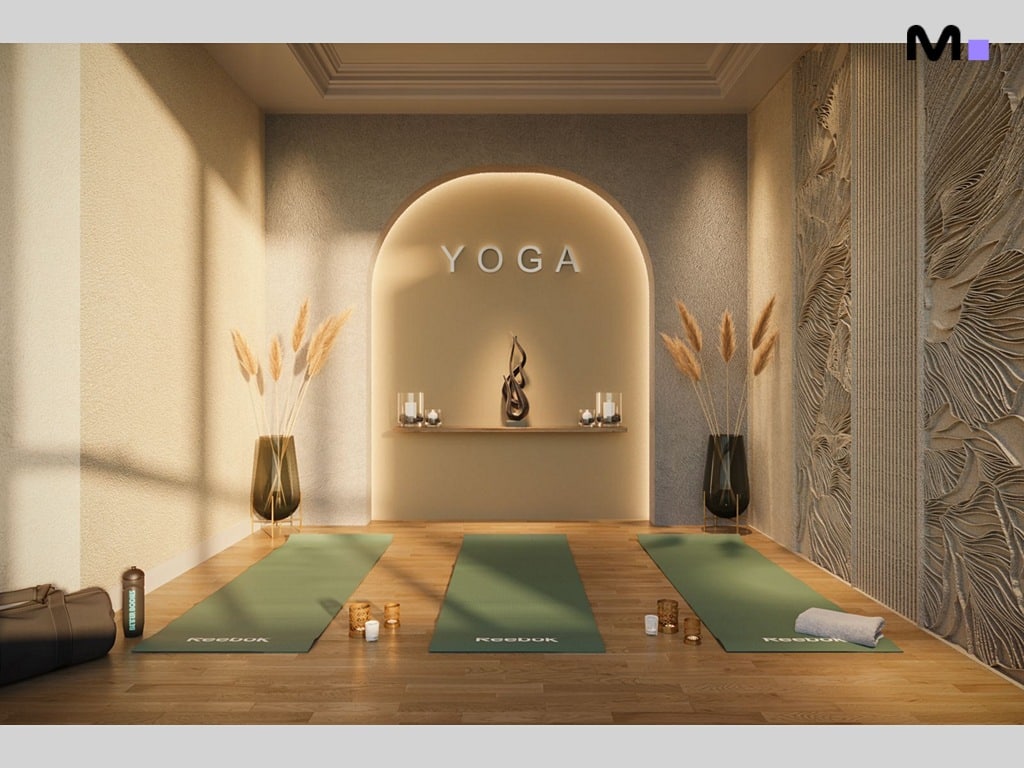 Interior de estúdio de yoga com tapetes verdes e decoração minimalista. "YOGA" escrito na parede.