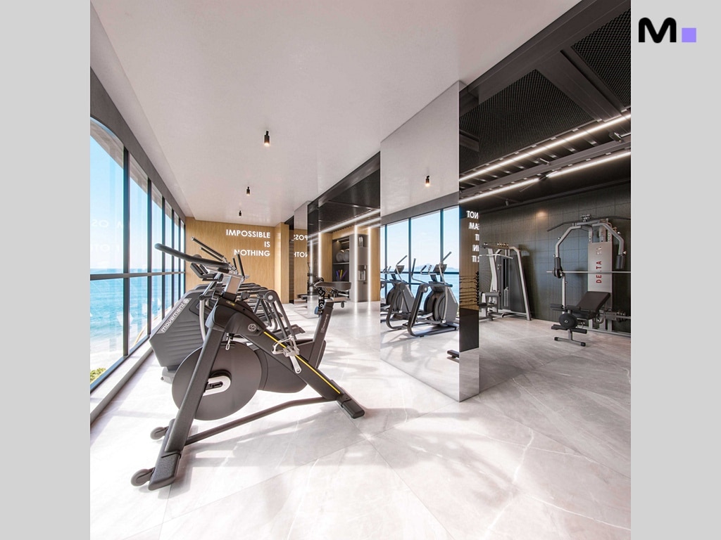 Academia moderna e bem iluminada no Hudson Park Residence com vista para o mar. "Impossible is nothing" na parede.