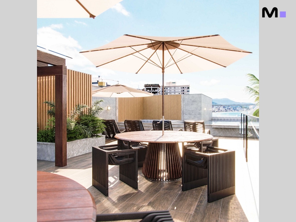 Área de lazer externa do Hudson Park Residence com mesas, cadeiras e guarda-sóis.