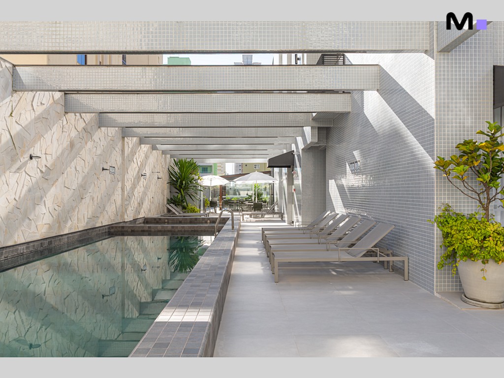 Piscina relaxante no Vila Aurora Residence com espreguiçadeiras e área de lazer moderna.