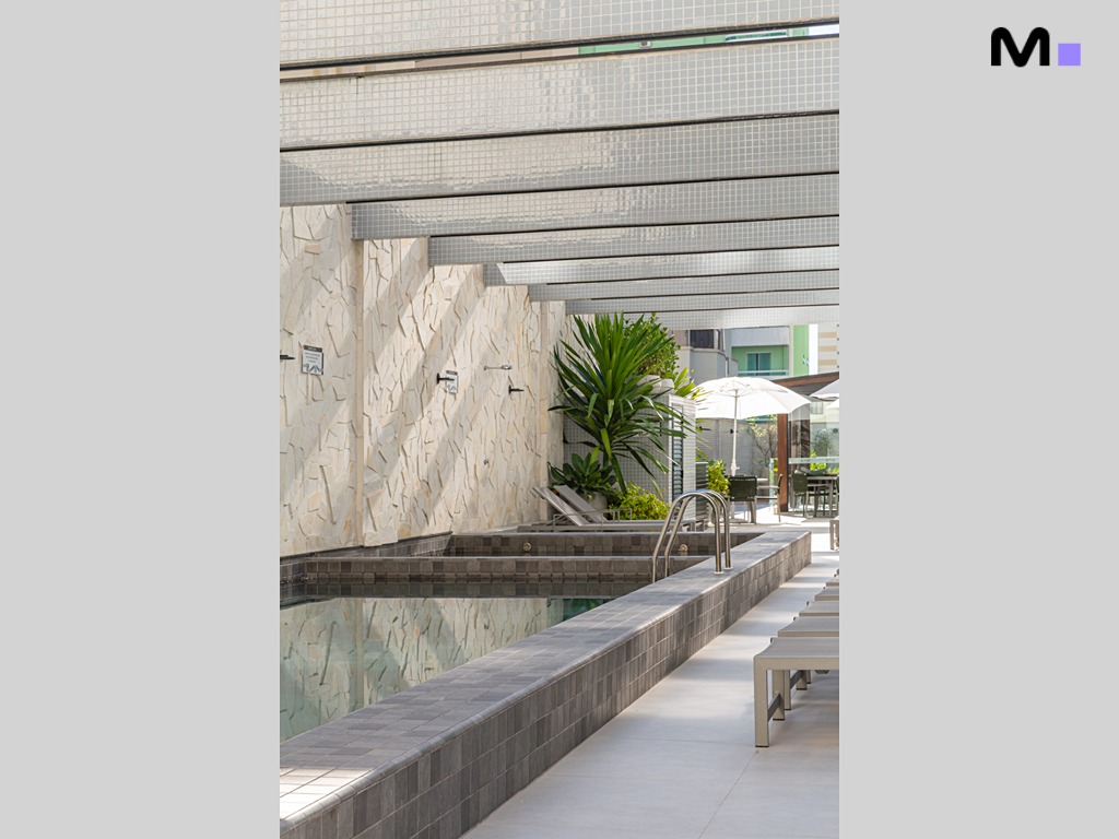 Piscina relaxante no Vila Aurora Residence, com espreguiçadeiras e área de lazer.