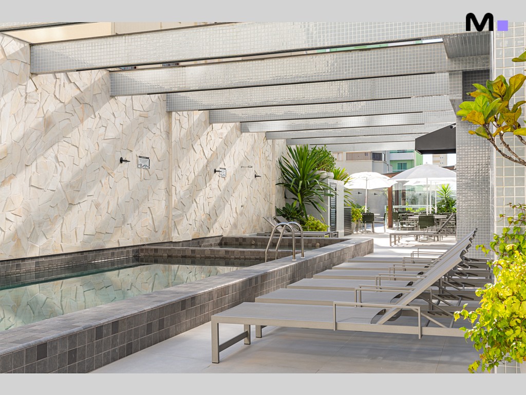 Piscina relaxante no Vila Aurora Residence com espreguiçadeiras e área de lazer.