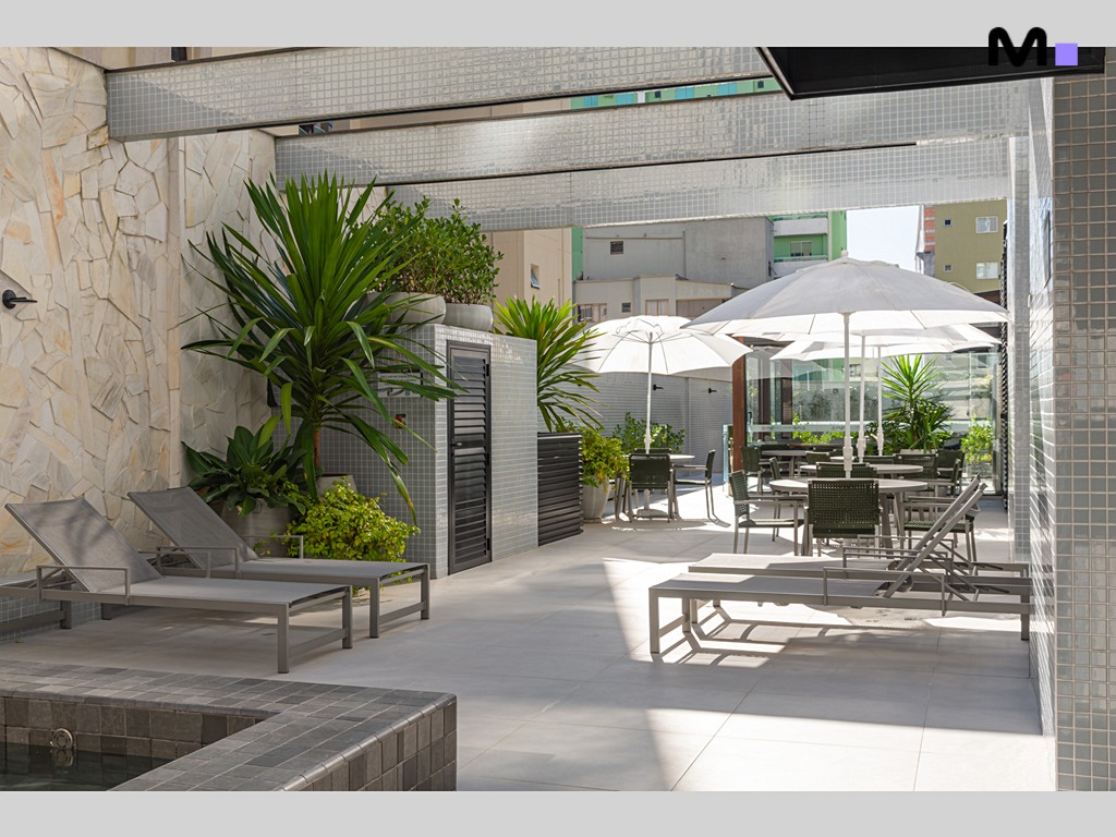 Área de lazer do Vila Aurora Residence com espreguiçadeiras e guarda-sóis.