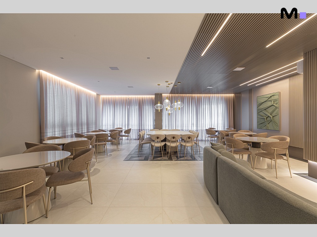 Interior elegante do Vila Aurora Residence com mesas, cadeiras e iluminação moderna.