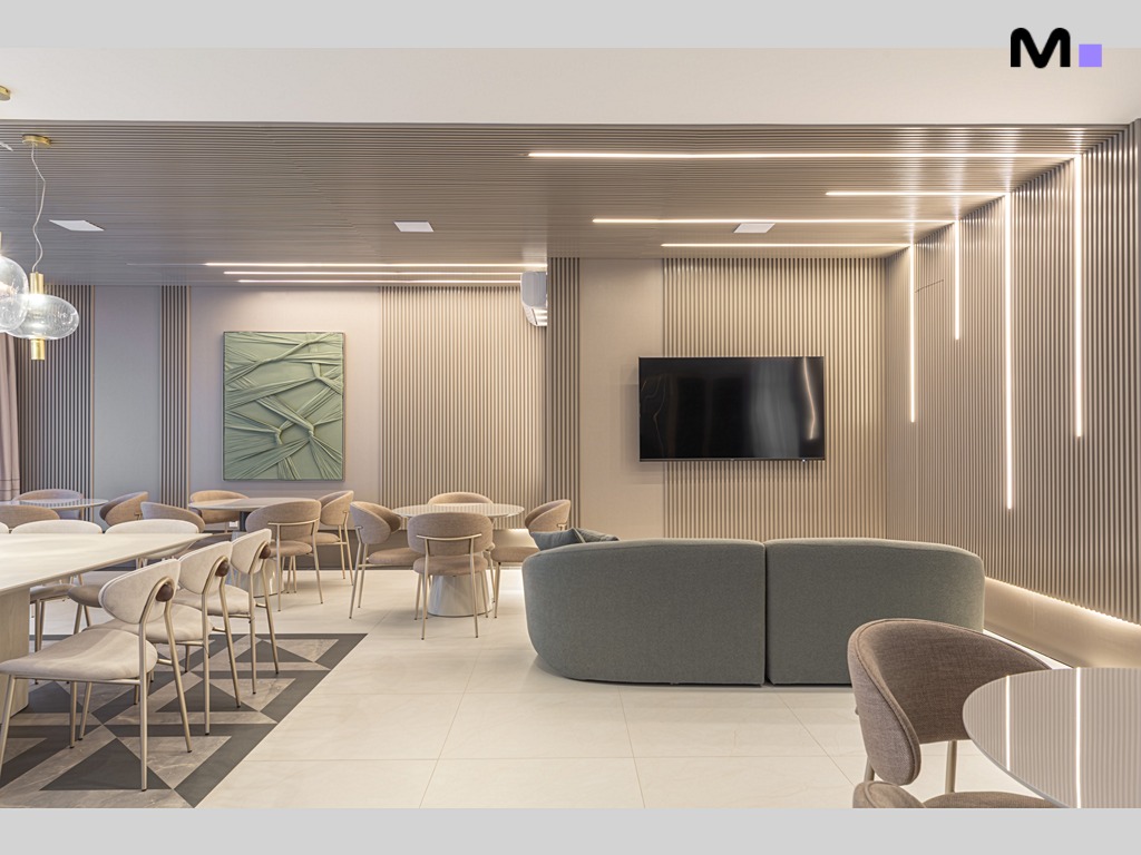 Interior moderno e elegante do Vila Aurora Residence com sofás, mesas e iluminação linear.