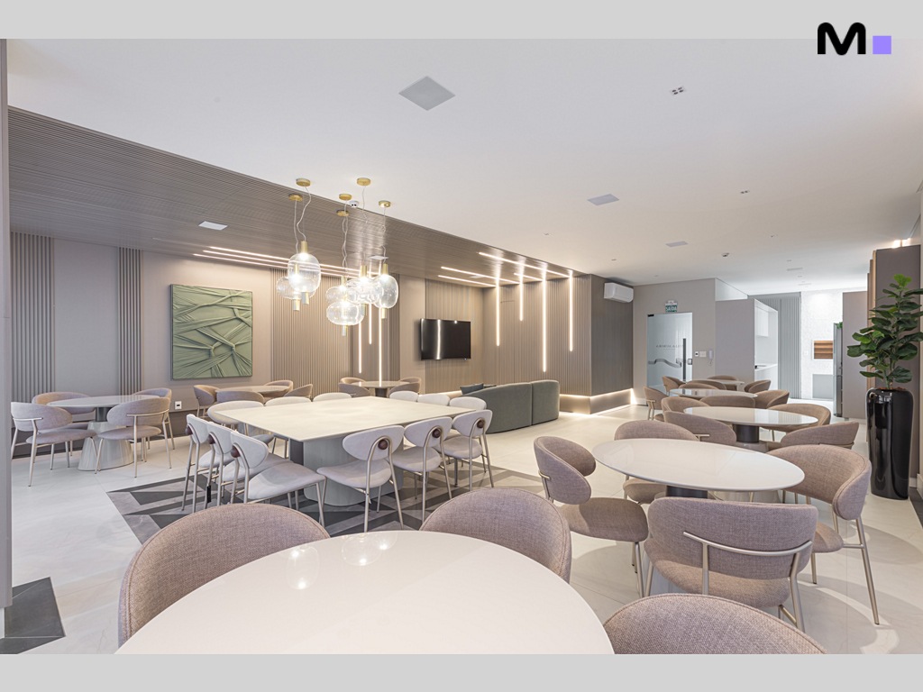 Salão de festas moderno no Vila Aurora Residence com mesas redondas e iluminação elegante.