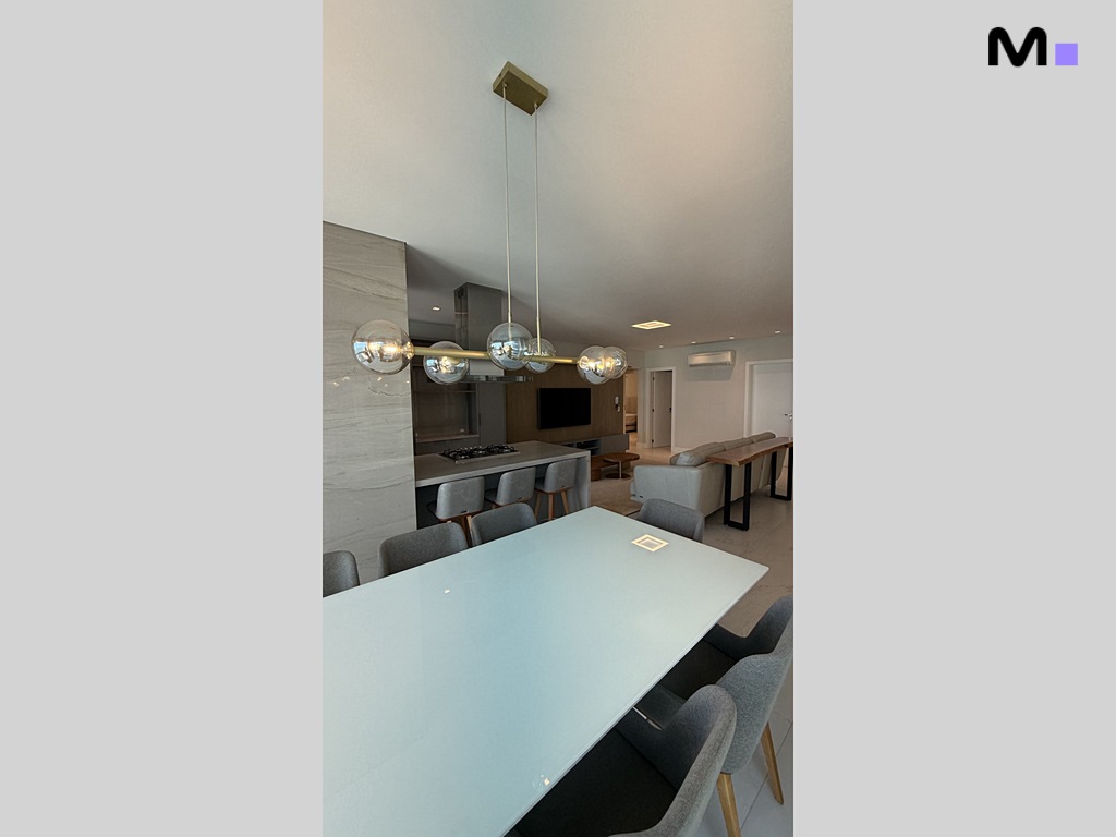 Interior moderno com mesa de jantar branca e luminária pendente esférica. Design do Garden Square Residence.