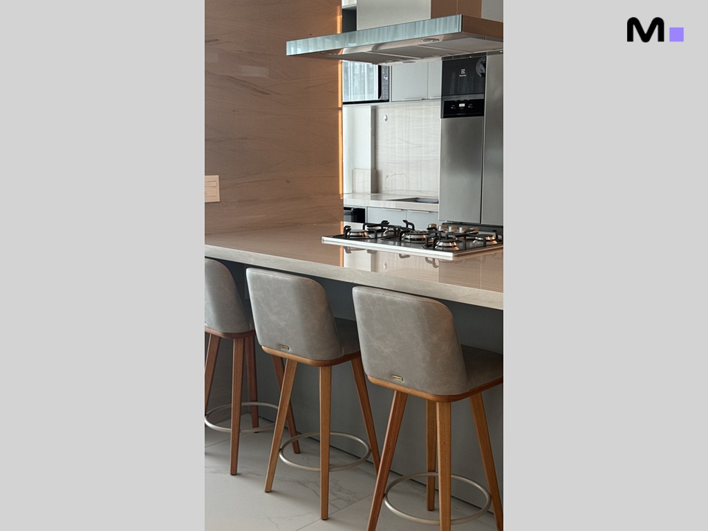 Cozinha moderna com bancada, banquetas de madeira e eletrodomésticos de inox. Residência Garden Square.