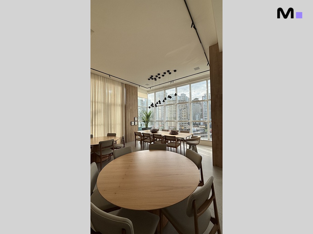 Sala de jantar ampla e iluminada no Garden Square Residence, com mesa redonda e vista da cidade.