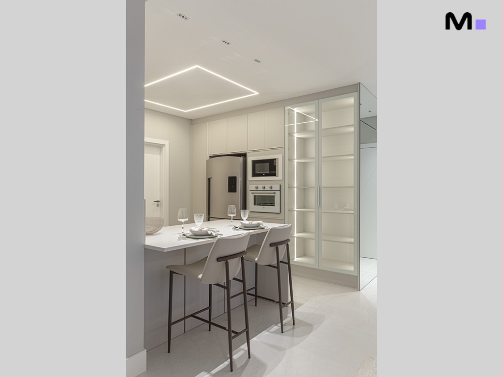 Cozinha moderna e iluminada da Vila Aurora Residence com ilha, cadeiras e armários brancos.