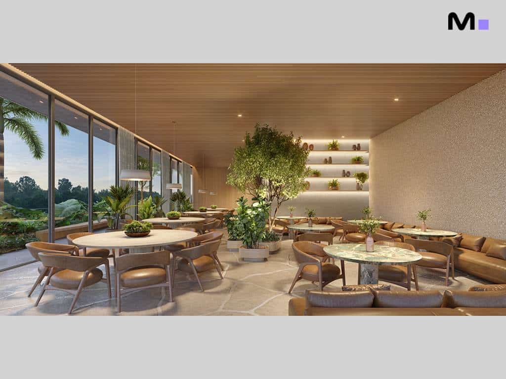 Interior do Lagom Perequê Residence com mesas, cadeiras e plantas, criando um ambiente acolhedor e elegante.