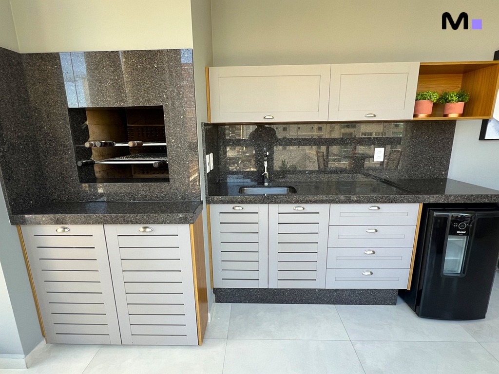 Cozinha gourmet com churrasqueira, pia e armários cinzas. Design moderno e elegante.