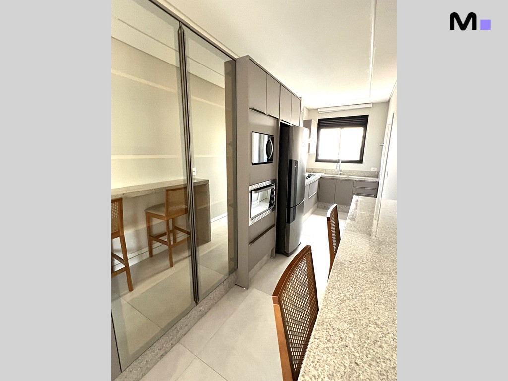 Cozinha moderna da Realta Residence com armários cinza e bancada clara.