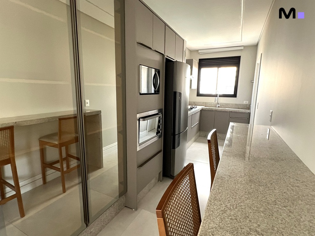 Cozinha moderna e elegante com ilha e armários cinzas. Realta Residence.