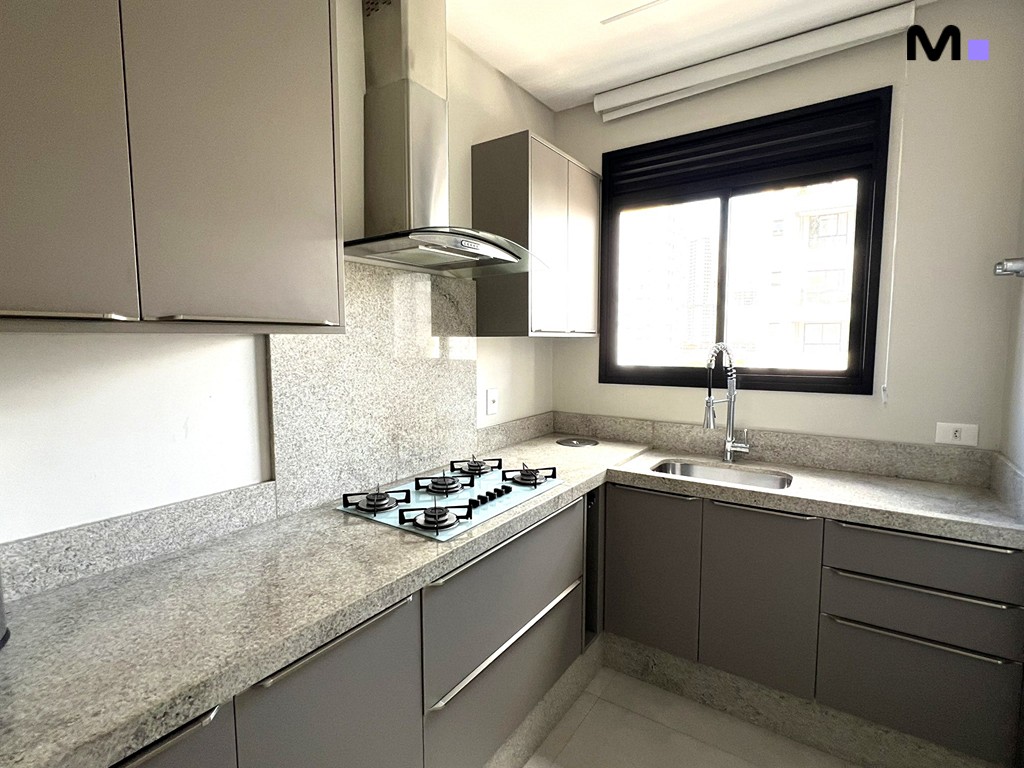 Cozinha moderna com armários cinza e bancada de granito, parte do Realta Residence.