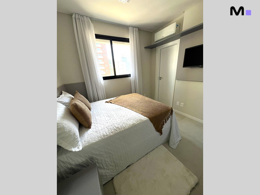 Quarto aconchegante no Realta Residence: cama de casal com manta marrom e luz natural.