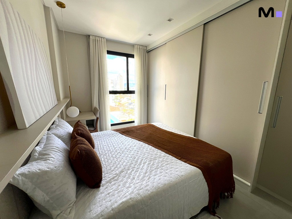 Quarto moderno e iluminado no Realta Residence com cama de casal, cortinas e vista da cidade.