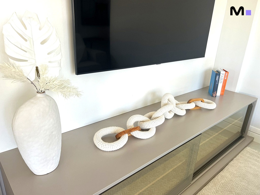 Decoração moderna com corrente decorativa, vaso e TV na Realta Residence.
