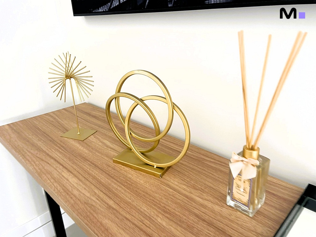 Decoração dourada moderna em mesa de madeira clara. Realta Residence.