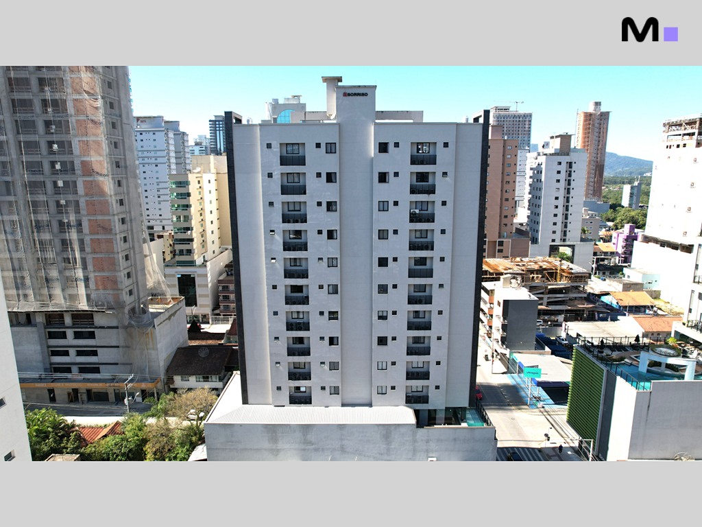 Edifício Realta Residence em meio à paisagem urbana, com outros prédios ao fundo.