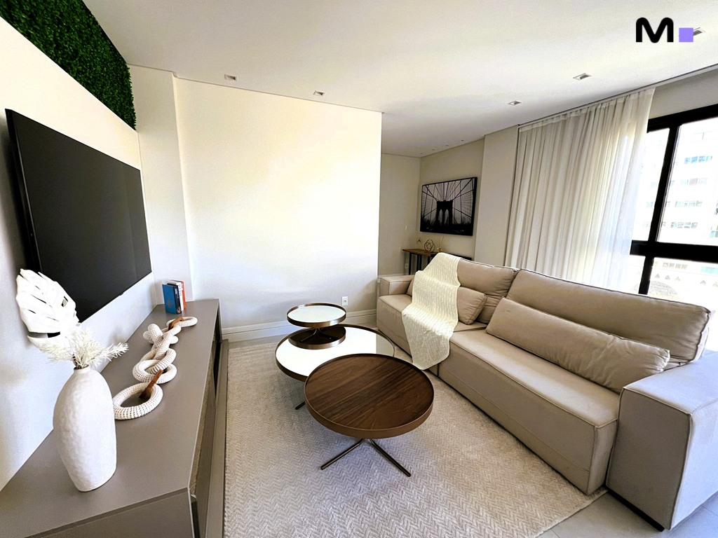 Sala de estar aconchegante da Realta Residence: sofá bege, tapete claro e mesa de centro moderna.