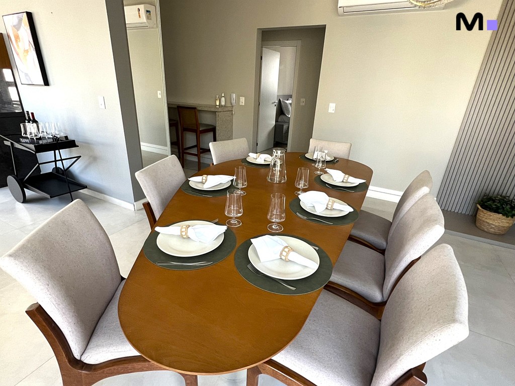 Mesa de jantar posta no Realta Residence. Decoração elegante com louça branca e detalhes em madeira.